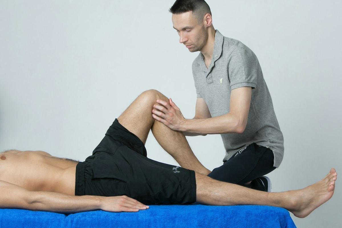 Clinician examining a patient's knee during recovery
